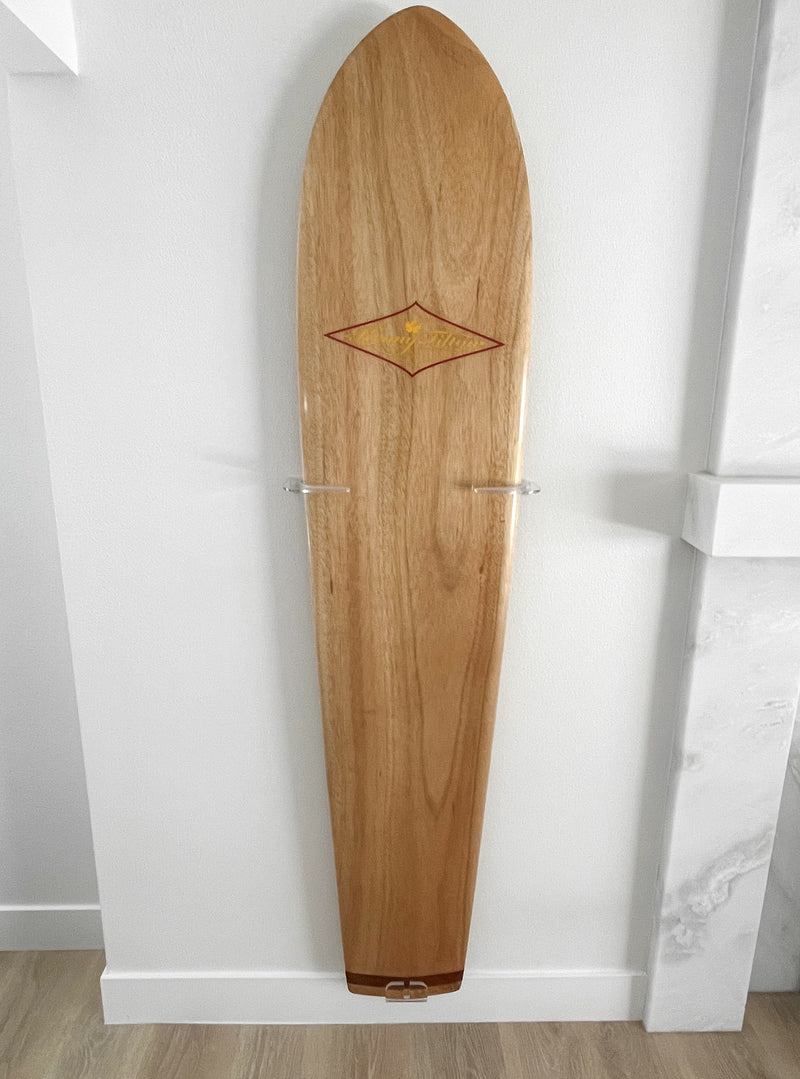 Wood Alaia Surf board, mounted in the vertical position on the wall, using clear acrylic surfboard mounts.