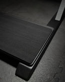 Downward angle of the blackout foamy freestanding surf rack base showing the black foam protective foam. The wooden rack is flat-black.