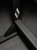 Middle portion of the blackout freestanding surf board rack. The wooden rack is flat-black and shows beautiful wood grains. The white Epic Surf Racks Diamond Logo is on the inside of the rack.