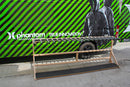 Custom freestanding vertical surfboard rack for the hurley pro. The empty rack has slots to hold up to 18 surfboards in the vertical position. In the background there is a van with Hurley branding that says Phantom projects and True Innovation with the picture of a jacket. The van is painted in green and black stripes.