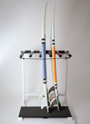 Marshmellow surfboard rack that is made of a marshmallow colored wood. The rack has slots for 5 surfboards, but is only holding two shortboards. The rack has a black foam base at the bottom where the boards lay.