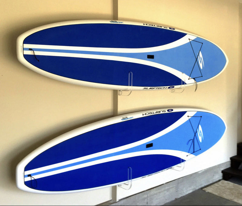 SUP acrylic wall rack mounted on the wall holding 2 blue  Stand Up Paddleboards