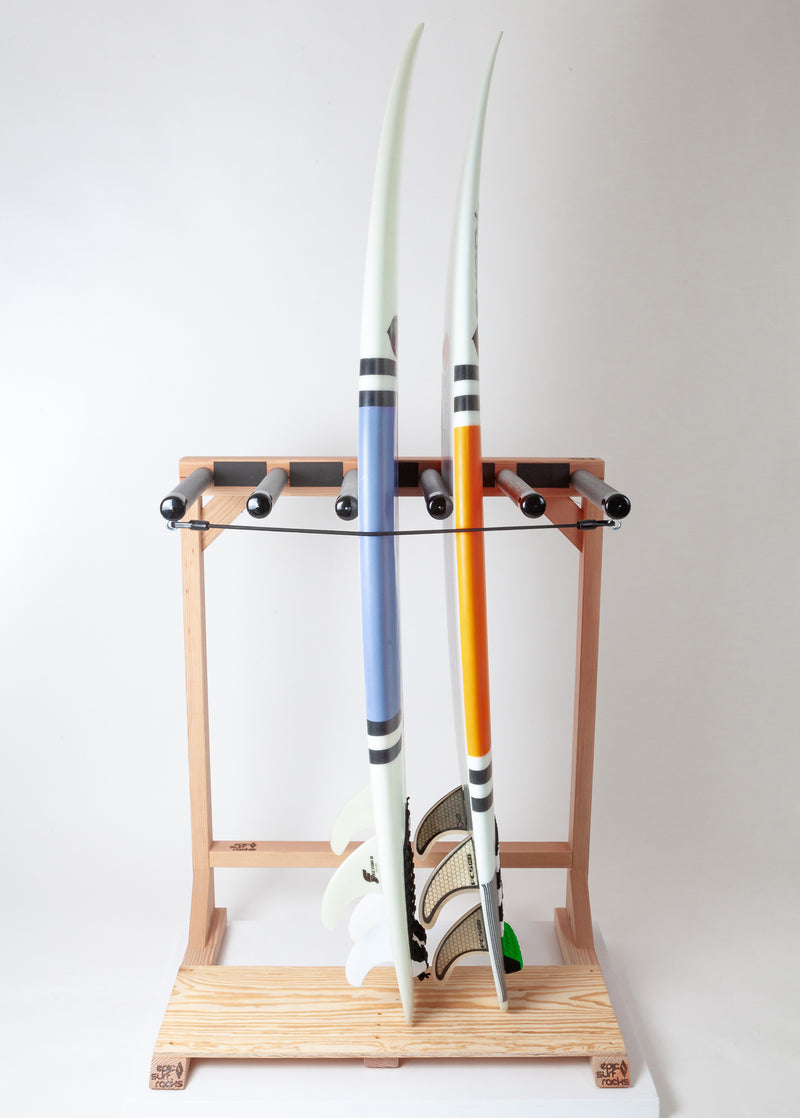 Woody freestanding surfboard rack made for storing 5 surfboards.  The rack is shown holding 2 shortboards, one blue, and one orange.  The image has a grey background.