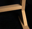 Red Oak freestanding surfboard storage rack bottom corner showing high quality wood grains with black backdrop