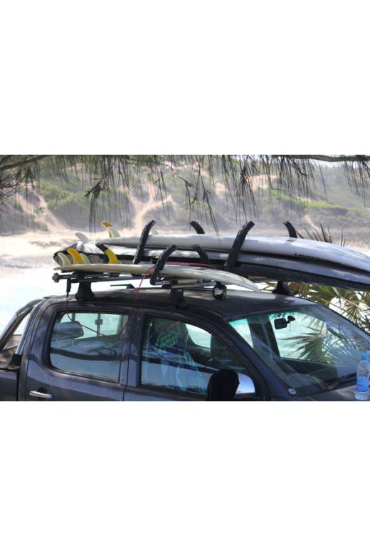 Locking Surfboard Roof Rack shown with surfboards mounted to the roof. The beach is in the background.