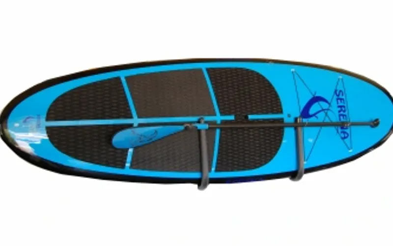 Front view of the SUP wall Cradle.  The rack is u-shaped and mounted to the wall.  The rack is holding a blue SUP board, and a paddle.  The board is mounted flush against the wall in the horizontal position.  The background of the image is white. 