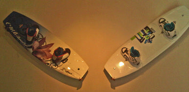 Customer photo of the blond wall rack holding two wakeboards.  The boards are mounted at a 45 degree angle to the floor. 