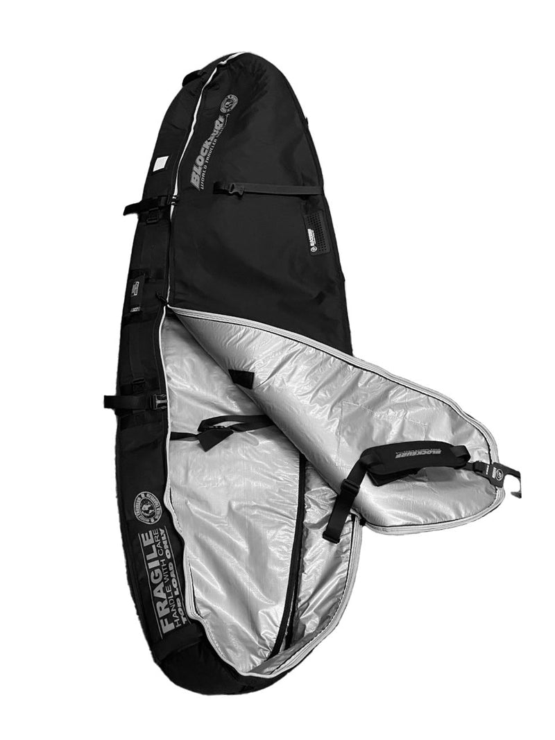 A heavy duty compact surfboard travel bag laying top side on the floorA close up image of a half unzipped black surfboard travel bag that has a zipper system that is heavy duty in appearance, yet smooth to operate.