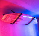 Metal Wall Rack at a 45 degree angle shown holding a surfboard with purple pink and blue lights. 