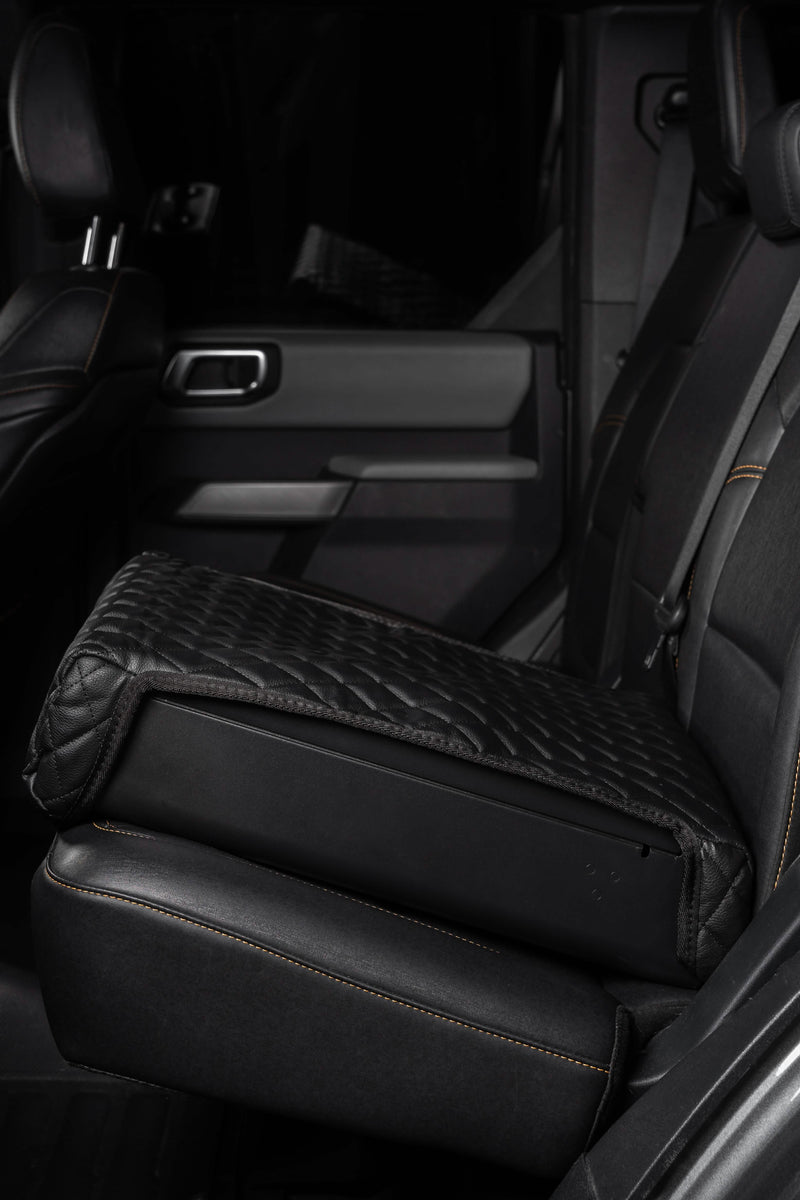 Side view of the Boostedsafe installed in the backseat of a luxury vehicle with the included safety cover installed .