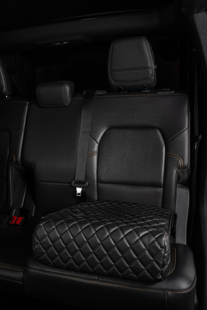 Boostedsafe elite shown in stalled in the back of a vehicle with the cover installed, the safe is in the locked position to the vehicle, and the main door is locked.