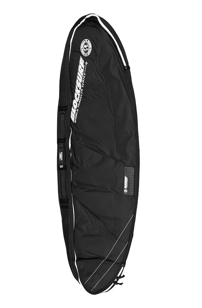 Thick and heavy duty black compact surfboard travel bag laying on facing up showing the side straps that keep the surfboards stable.