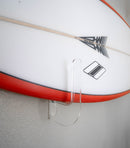 Surfboard with a clear holder attached to a wall, board is flush and close to the wall. 