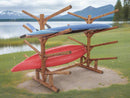 Freestanding SUP Log Kayak & Canoe Rack shown next to a lake with mountains in the background.  The rack is on a grass nole.