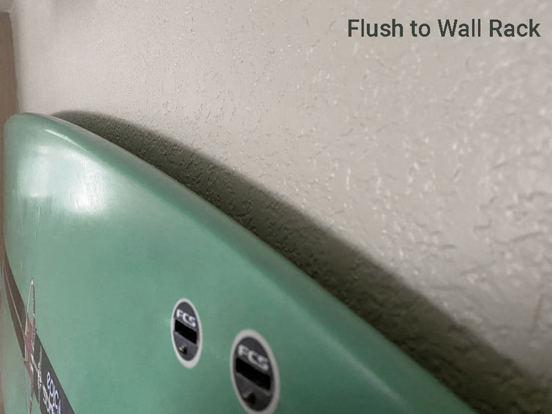 acrylic surfboard wall rack that is flush to the wall showing a green surfboard very close to the wall 