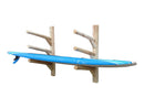 3 SUP Log Wall Rack Unfinished (sanded) version. The rack is mounted to a white wall and holding a blue stand up paddle board on the lowest level. 
