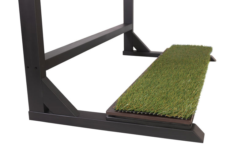 Close up detail shot of the Blackout Grassy Surf Rack base.  The faux grass base is sitting on top of a brown plank.  The flat black surf rack is sitting on top of a white background.