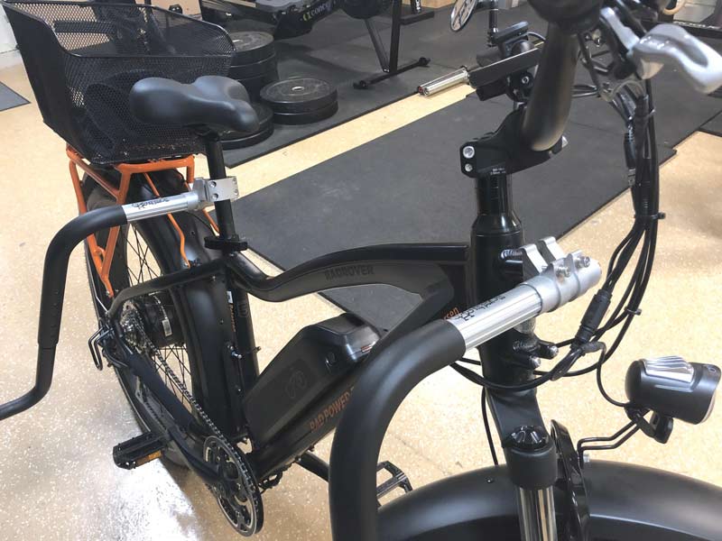 SUP bike rack shown mounted to a black e-bike.  The rack is mounted to the bike's seat, and also to the front frame-mounts. 