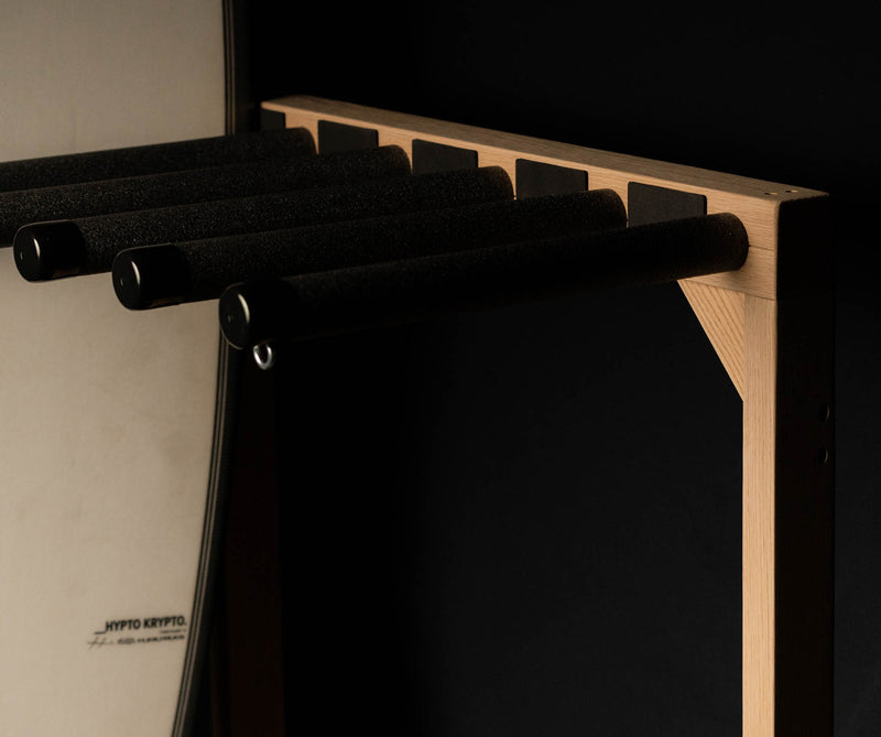 Top half of red oak freestanding surfboard rack on black background with dramatic lighting. 