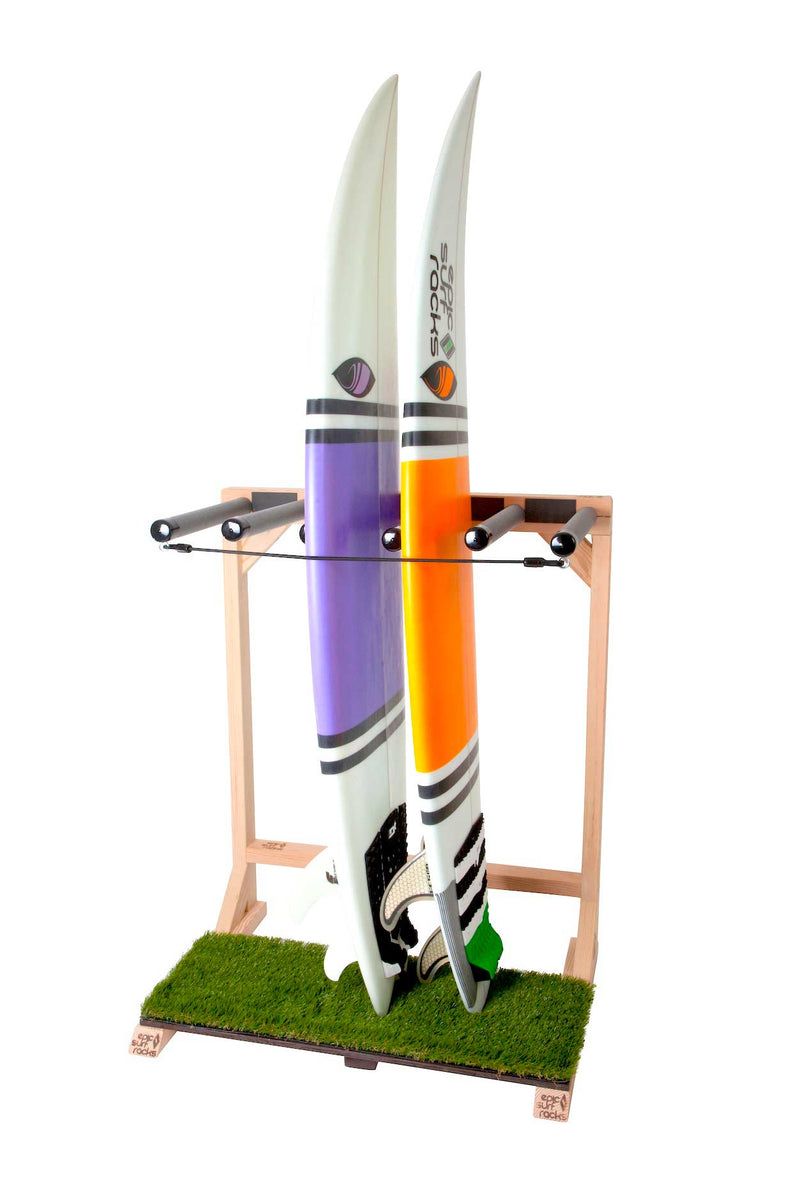 Grassy Surfboard Rack main image holding two high performance surfboards in the vertical position.  The rack can hold five boards in this image.  Vibrant grass base is where the boards sit on, in the vertical position. Rack is made of high quality wood. 