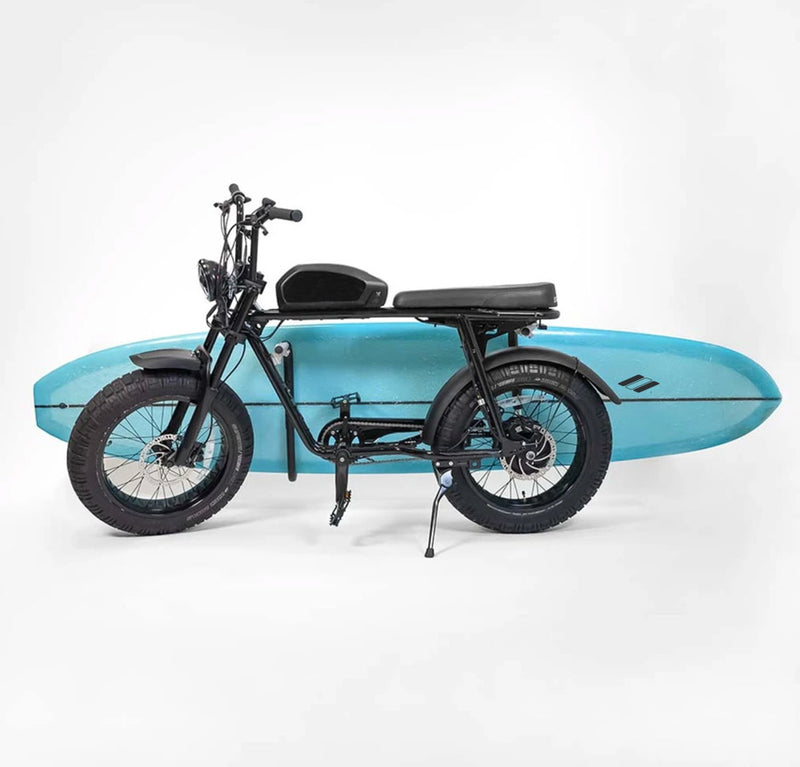 black super-73 e-bike holding light blue longboard using surfboard rack with white background