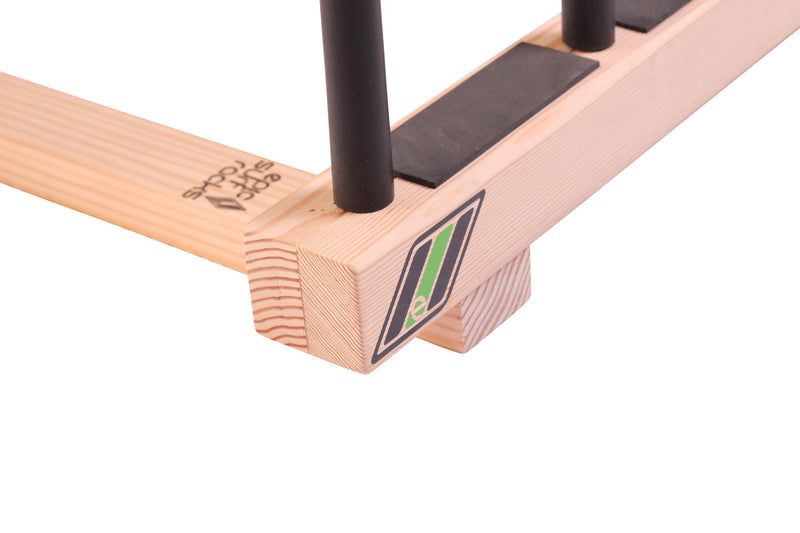 Close up of The Pig Dog Floor Rack for Surfboards & SUP.  The image shows the quality of the surf rack's wood and the high quality black foam inserts used to protect the watercraft.  Epic Surf Racks logo is branded into the wood. 