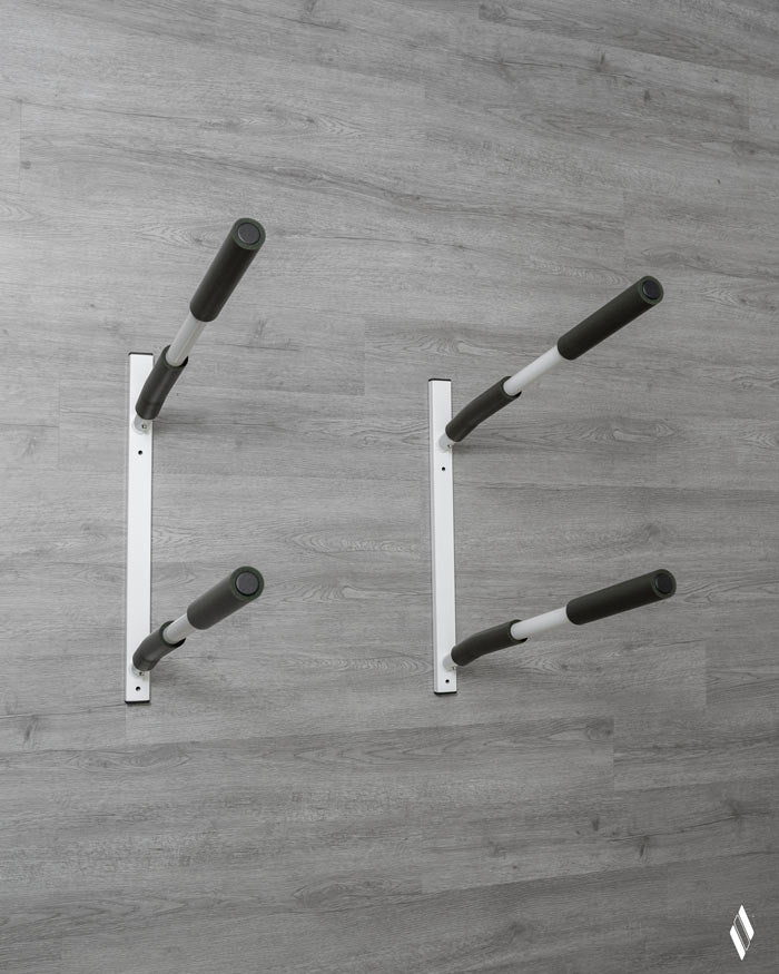 Front facing picture of the SUP / Kayak wall rack mounted on a grey wooden wall.  The rack is covered in a high gloss white paint and covered in grey/green protective foam. 