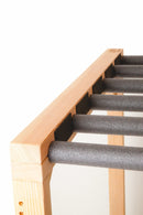 Top image of the SUP Foamy - 3 Board Stand Up Paddle / Longboard Rack.  The rack is made of wood, and has black foam dowels coming out of the rack that holds the watercraft. 