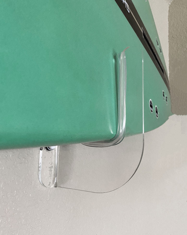 Close up image of the acrylic flush mount surfboard rack.  The image shows how close the surfboard is mounted to the wall using the rack.  The clear rack also has a clear strip protecting the surfboard from damage. 